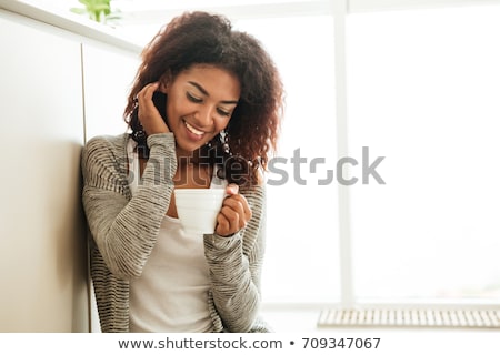 Сток-фото: Curly Woman Sitting At The Kitchen Drinking Tea