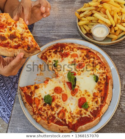 Stock fotó: Hand Dip A Slice Of Pizza Into Tomato Sauce In A Bowl