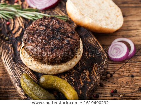 Stock fotó: Fresh Raw Minced Pepper Beef Burgers On Vintage Chopping Board With Buns Onion And Tomatoes On Woode