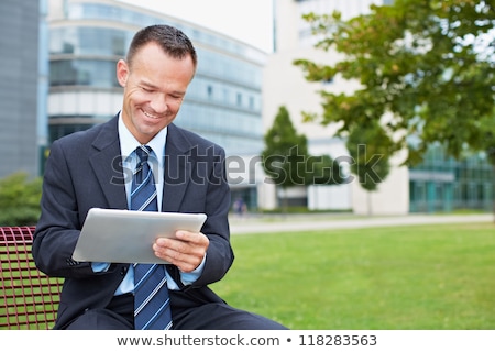 Zdjęcia stock: Businessman With Tablet Computer On Bench In Park