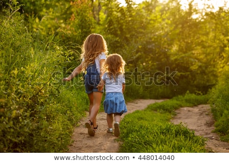 Foto d'archivio: Two Little Cute Girls On Lawn In The Park