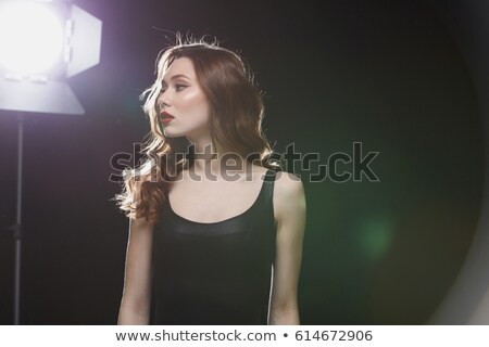 Foto stock: Charming Young Woman With Red Lips Standing Near Studio Spotlight