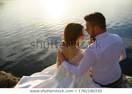 Stok fotoğraf: Couple Sitting On Rock Against Sea