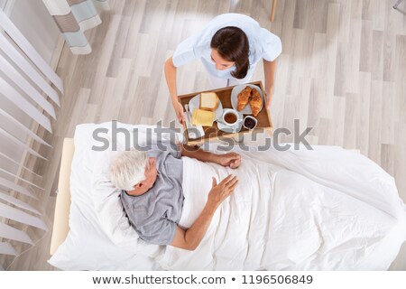 Stok fotoğraf: Nurse Serving Food To Senior Male Patient In Clinic