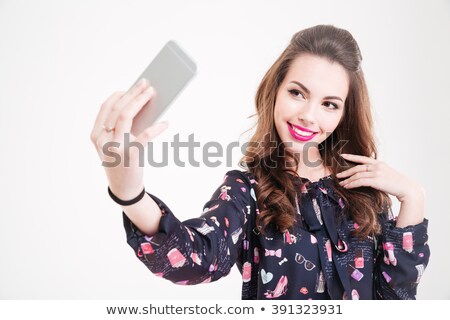 Foto d'archivio: Cheerful Charming Young Woman Making Selfie Using Smartphone