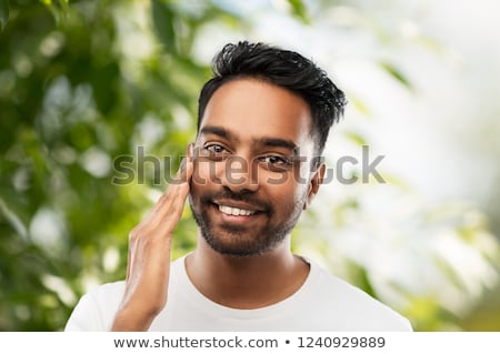 Foto stock: Smiling Indian Man Touching His Beard