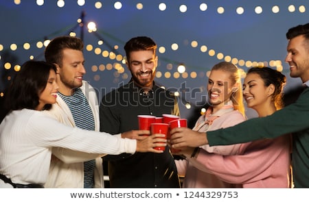 ストックフォト: Friends Clinking Party Cups On Rooftop At Night