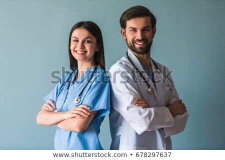 Foto stock: Young Doctor Standing Cross Armed With Male And Female Nurses In Background