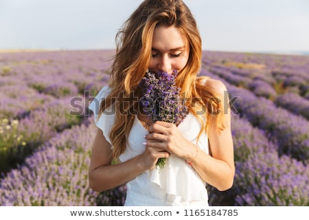 Stock photo: Smiling Woman Smelling Flower