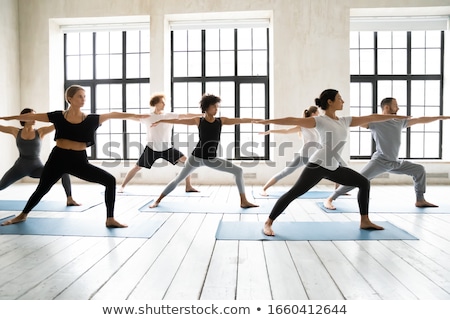 Foto stock: Two Women Stretching And Practicing Yoga In Studio