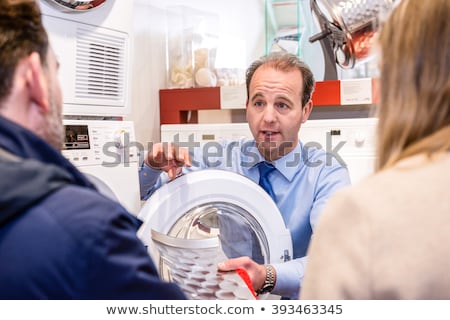 Stock fotó: Salesman Explaining To Couple In Washing Machine Department