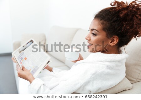 [[stock_photo]]: Back View Image Of Young African Woman Reading Gazette