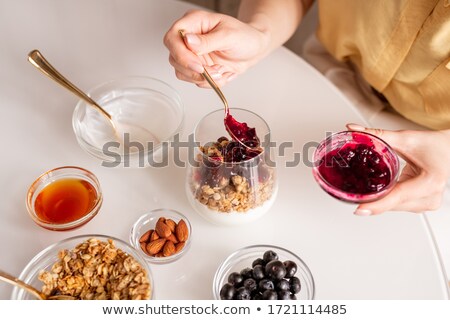 ストックフォト: Woman Hands Hold Bowl With Appetizing Healthy Granola Dessert With Pieces Of Strawberries Cream O