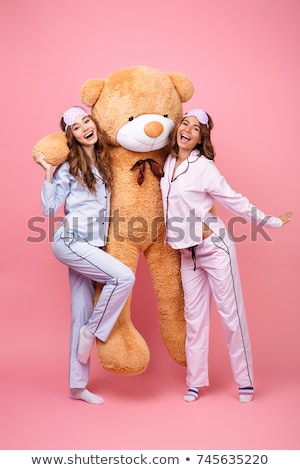 Stockfoto: Two Cheerful Girls Wearing Pajamas Standing