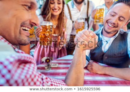 Stockfoto: Bavarian Friends Practicing The High Art Of Arm Wrestling