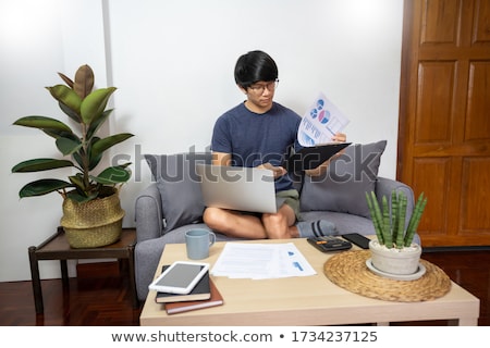 Stok fotoğraf: Asian Entrepreneur Working At Home On Some Project With His Lapt