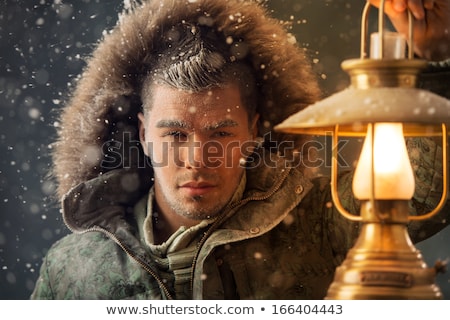 Сток-фото: Brutal Man Walking Under Snowstorm At Night Lighting His Way Wit