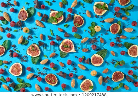 Foto stock: Summer Pattern With Chocolate Berries Almond Figs Mint On A Blue Background Creative Sweet Food