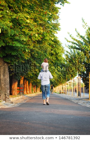 Foto stock: Father Carrying Son With Autumn Leaves In City