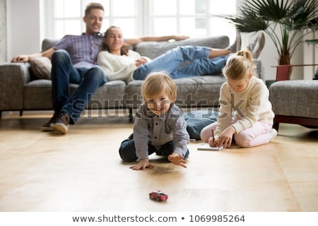 Foto stock: Image Of Smiling Cheerful Couple Sitting On Floor Near Sofa At H