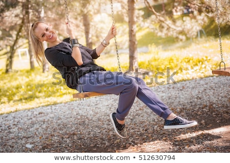 Foto stock: Fun Playful Young Woman Sitting On A Bench