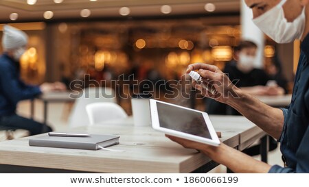 Stok fotoğraf: Man Disinfecting His Digital Tablet