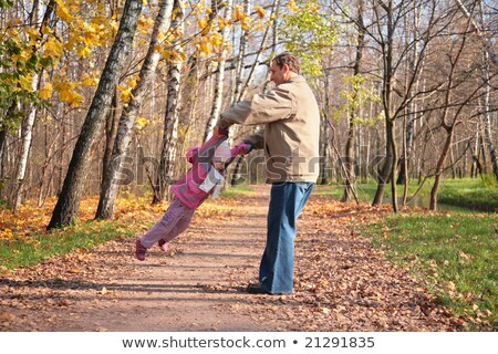 Сток-фото: Grandfather Rotates Granddaughter In Wood In Autumn