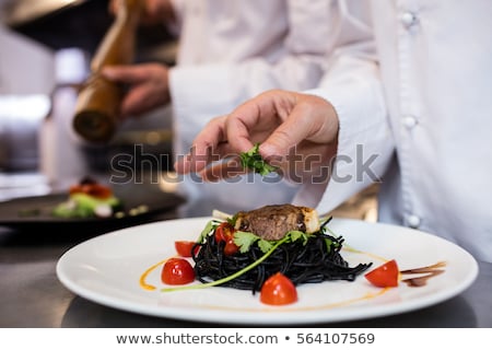 Stock photo: Close Up Of Chef Garnishing Meal On Counter