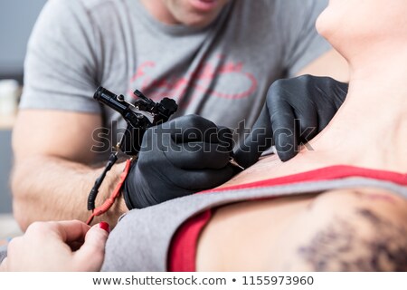 Close Up Of The Hands Of A Skilled Artist Making The Contour Of A Tattoo Foto stock © Kzenon