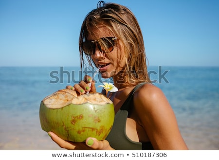 Stock photo: Attractive Young Woman Drinking Coconut Water On The Beach