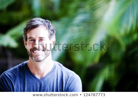 Stock fotó: Cheerful Pleasant Looking Man With Beard Looks Thoughtfully Aside Holds Fir Tree Wears Spectacles