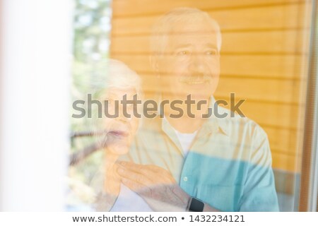 Сток-фото: Contemporary Affectionate Senior Spouses Standing By Window