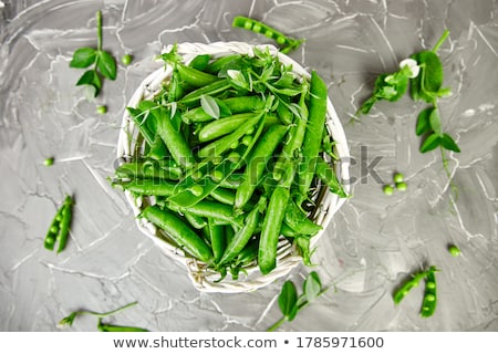 Foto stock: White Basket With Fresh Green Peas On Grey Background