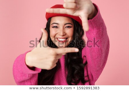 Foto stock: Image Of Asian Girl Smiling And Showing Photo Frame With Her Fin