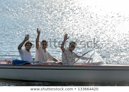 Stok fotoğraf: Silhouette Of Young Friends In Motorboats