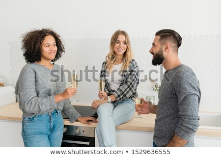 Stockfoto: Three Happy Young Friends With Flutes Of Champagne Making Toast For Holiday