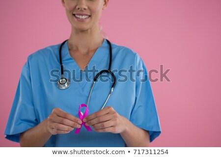 ストックフォト: Mid Section Of Female Doctor In Scrubs Showing Breast Cancer Awareness Ribbon