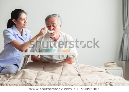 Stok fotoğraf: Caretaker Feeding Senior Man
