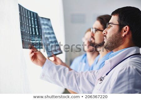 Foto d'archivio: Successful Radiologist In Blue Uniform Holding X Ray Image In Front Of Himself