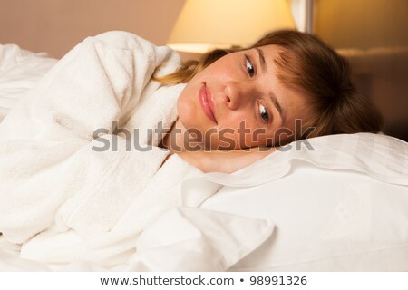 Woman Laying In Bed Wearing Bath Robe Foto stock © luckyraccoon