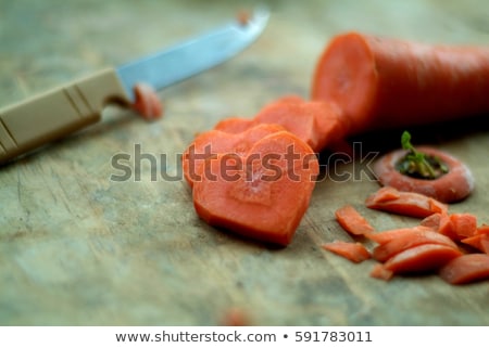 Stockfoto: Carrot Pieces In The Shape Of A Heart With Knife