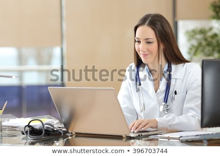Stock photo: Smiling Nurse At A Busy Desk