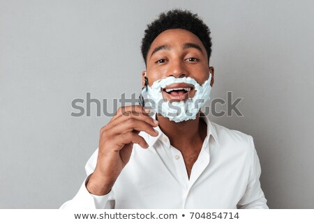 Stock photo: Close Up Portrait Of Young Man In Shaving Foam Holding Razor