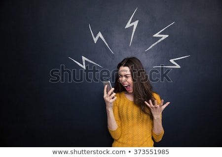 Foto stock: Young Woman Screaming Into Cell Phone