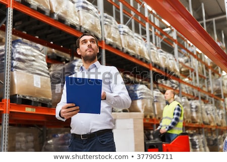 Foto stock: Worker And Businessman With Clipboard At Warehouse