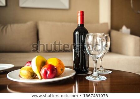 [[stock_photo]]: Bottle Of Red Wine And Empty Glasses With Dark Grapes Inside Vintage Wooden Box On Black Stone Backg