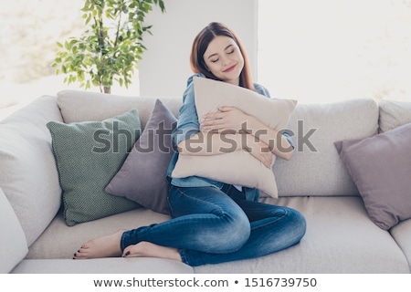 Stockfoto: Woman Hugging Pillow Sitting On A Couch