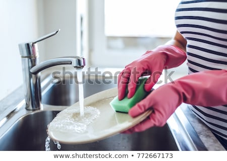 [[stock_photo]]: Elle · jeune · femme · faisant · la · vaisselle · dans · la · cuisine · à · la · maison