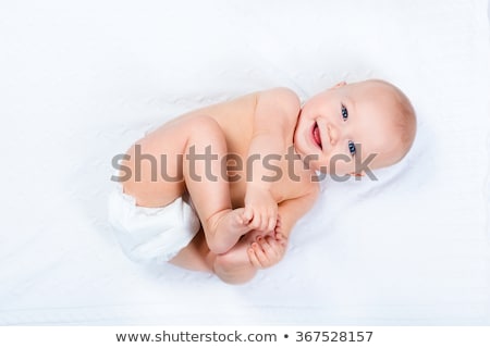 Stockfoto: Baby Girl Lying On White Sheet On The Bedroom