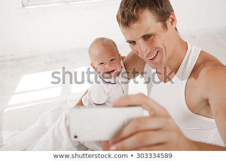 ストックフォト: Happy Father With Baby Taking Selfie At Home